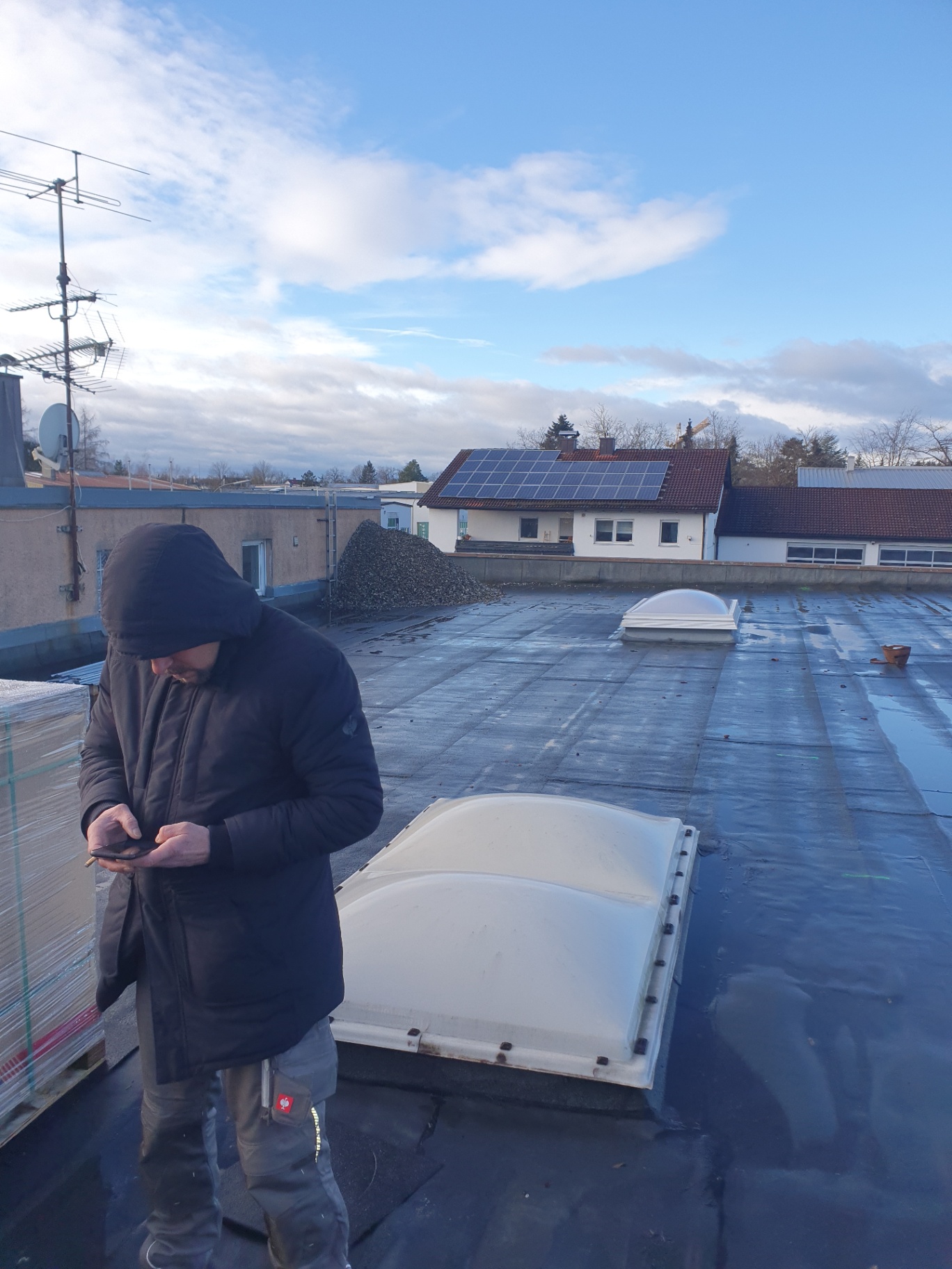 Monteur auf Flachdach bei der Arbeitsvorbereitung