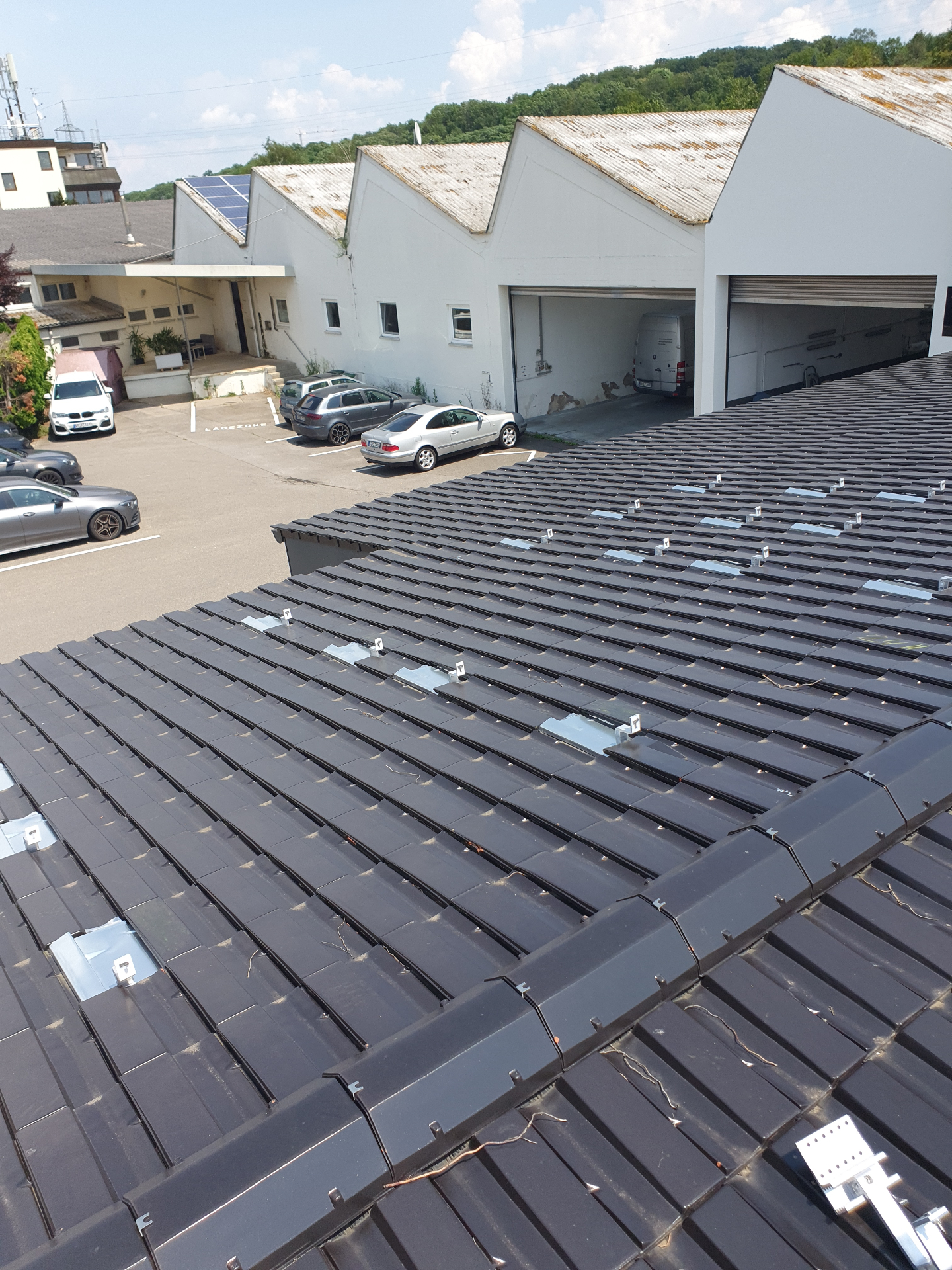 Photovoltaik-Anlage auf großem Ziegeldach mit Hallenansicht